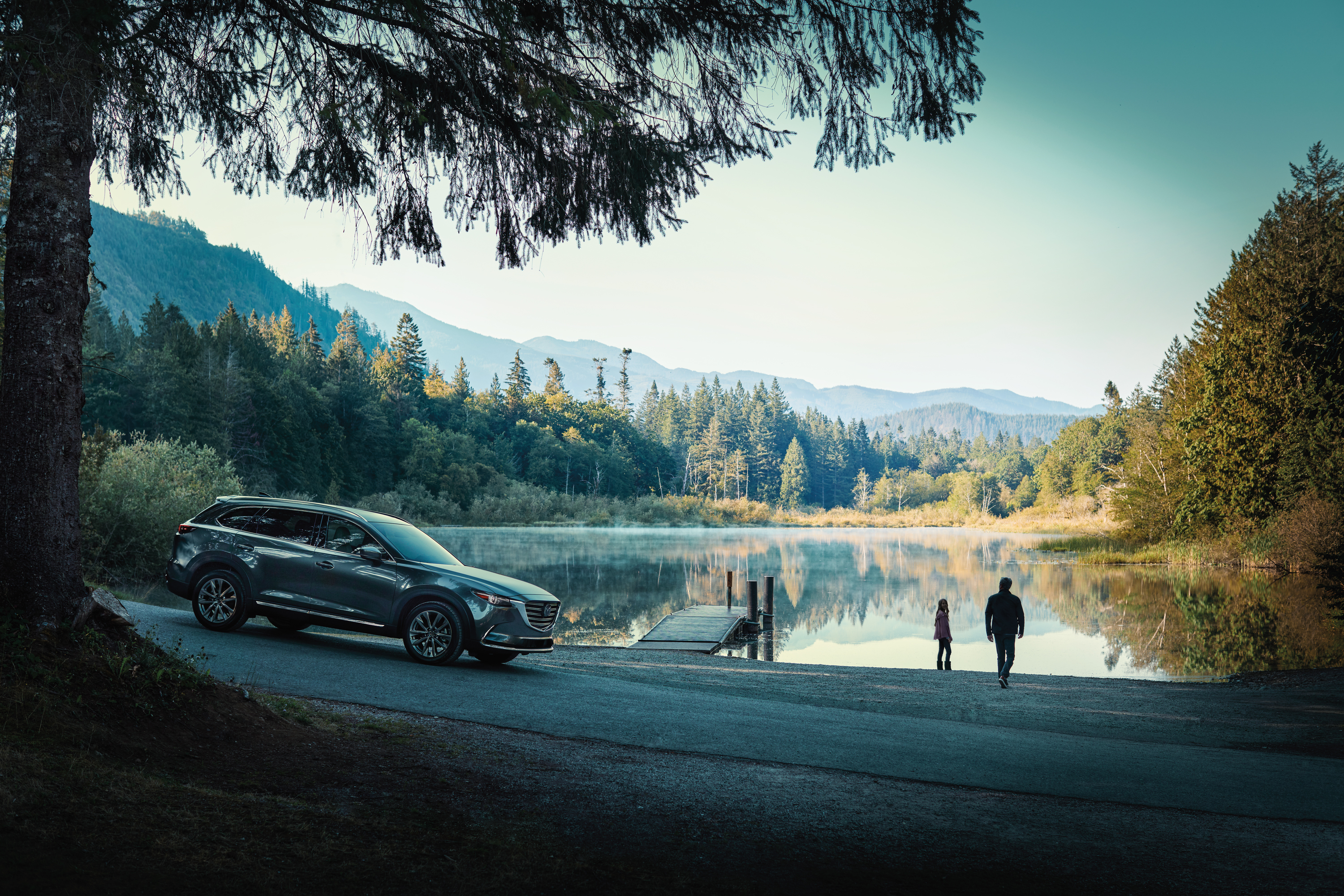 couple walking towards the lake, the 2020 Mazda CX-9 nearby.