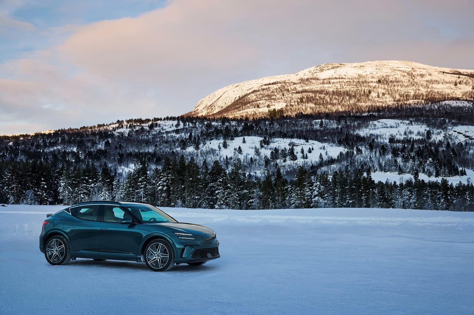 Genesis GV60 Performance AWD electric SUV parked in a snowy landscape, demonstrating all-wheel-drive capability and winter readiness.