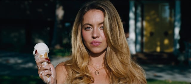 Close-up of a Sydney Sweeney holding ice cream, symbolizing the contrast between youthful innocence and mature themes in Euphoria.