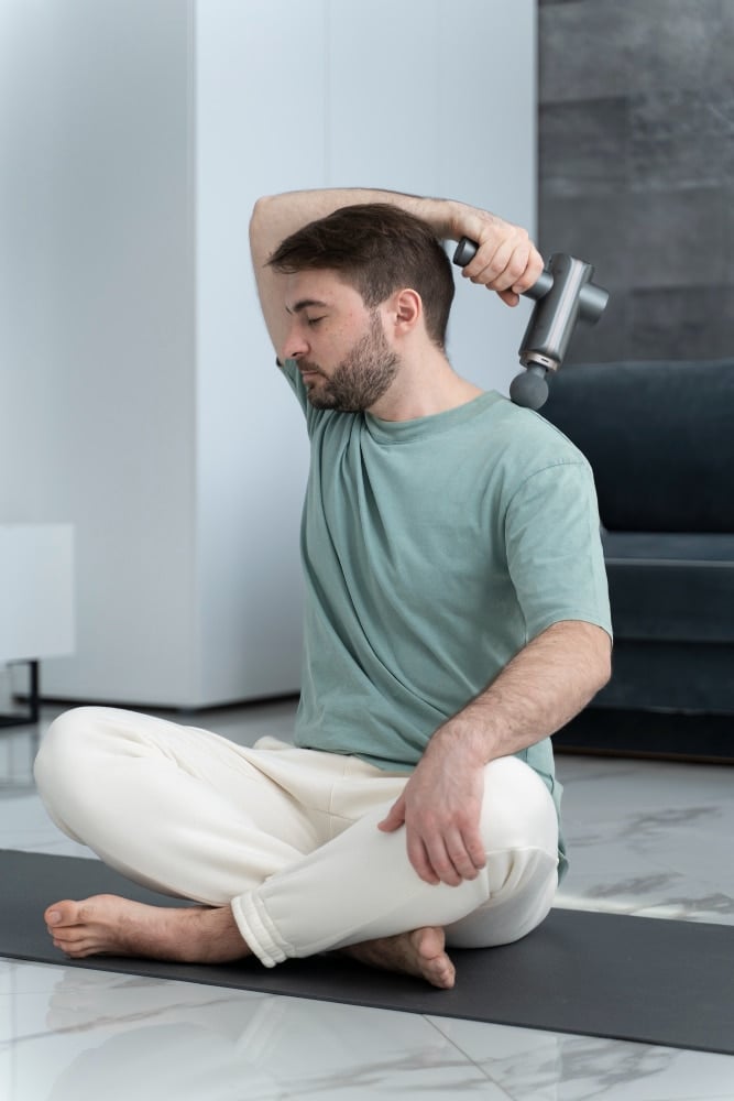 Man using Massage Gun For Soothing Aching Muscles