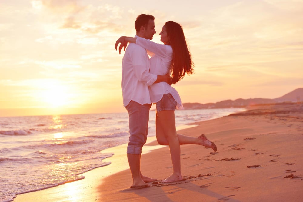 Happy young romantic couple in love have fun on beautiful beach at beautiful summer day