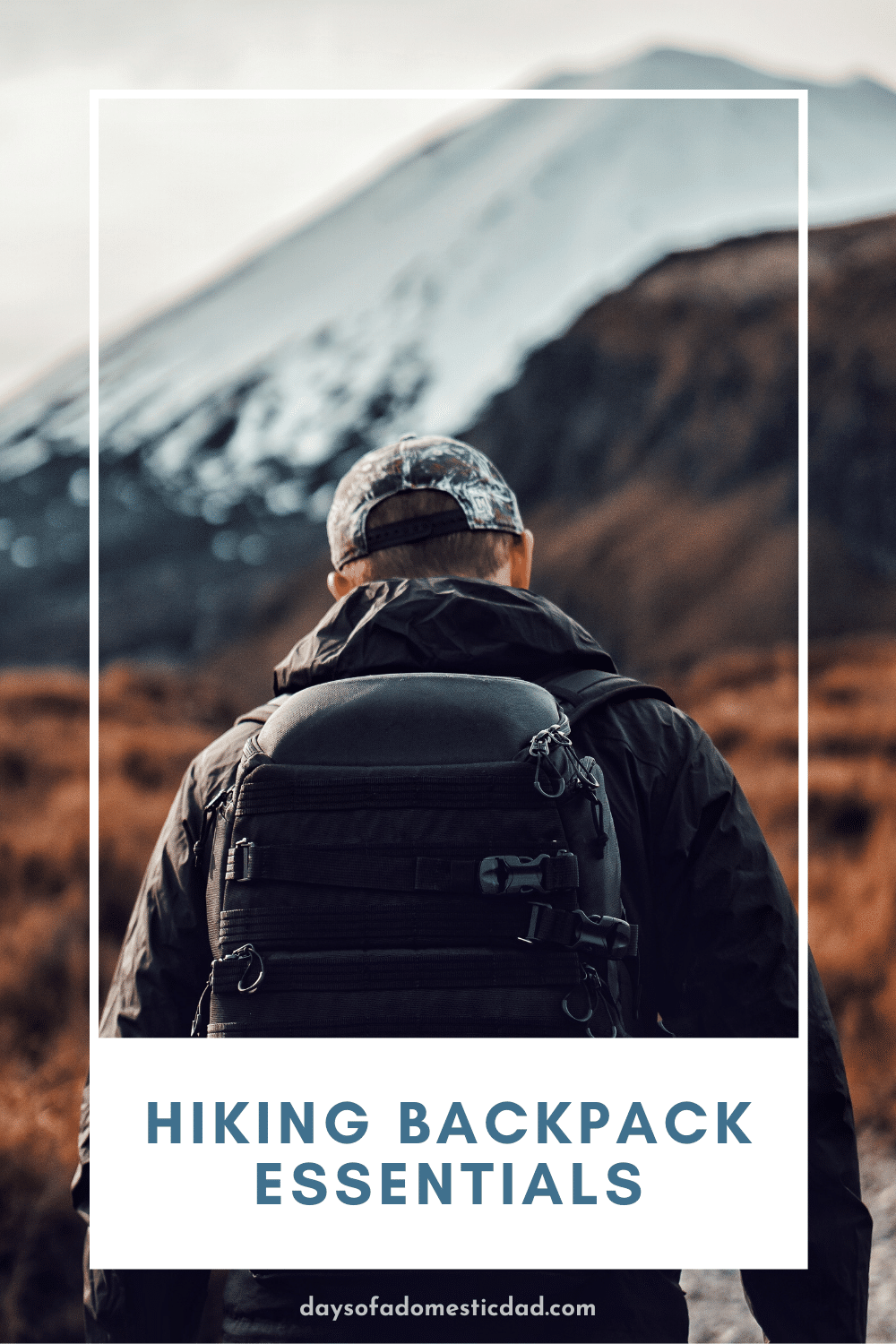 male hiking towards mountain with a backpack