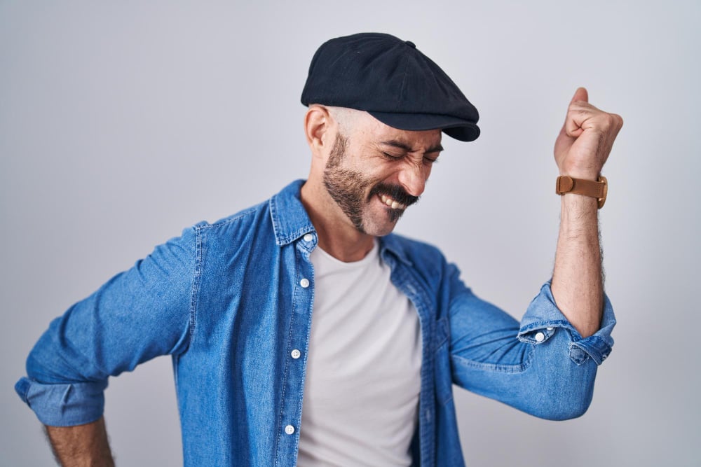 Free photo hispanic man with beard standing over isolated background dancing happy and cheerful, smiling moving casual and confident listening to music