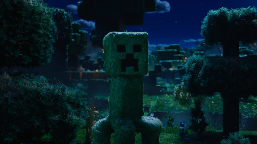A green Creeper, the infamous Minecraft enemy, lurks ominously in a lush, blocky forest under moonlight.