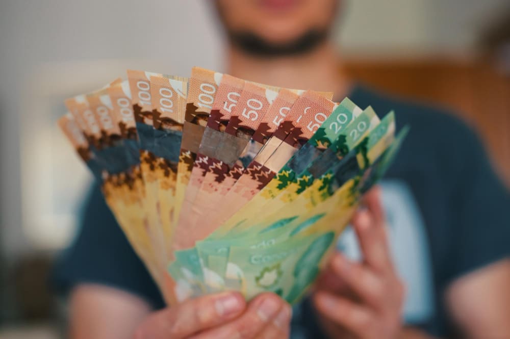Photo midsection of man holding banknotes of canadian dollars