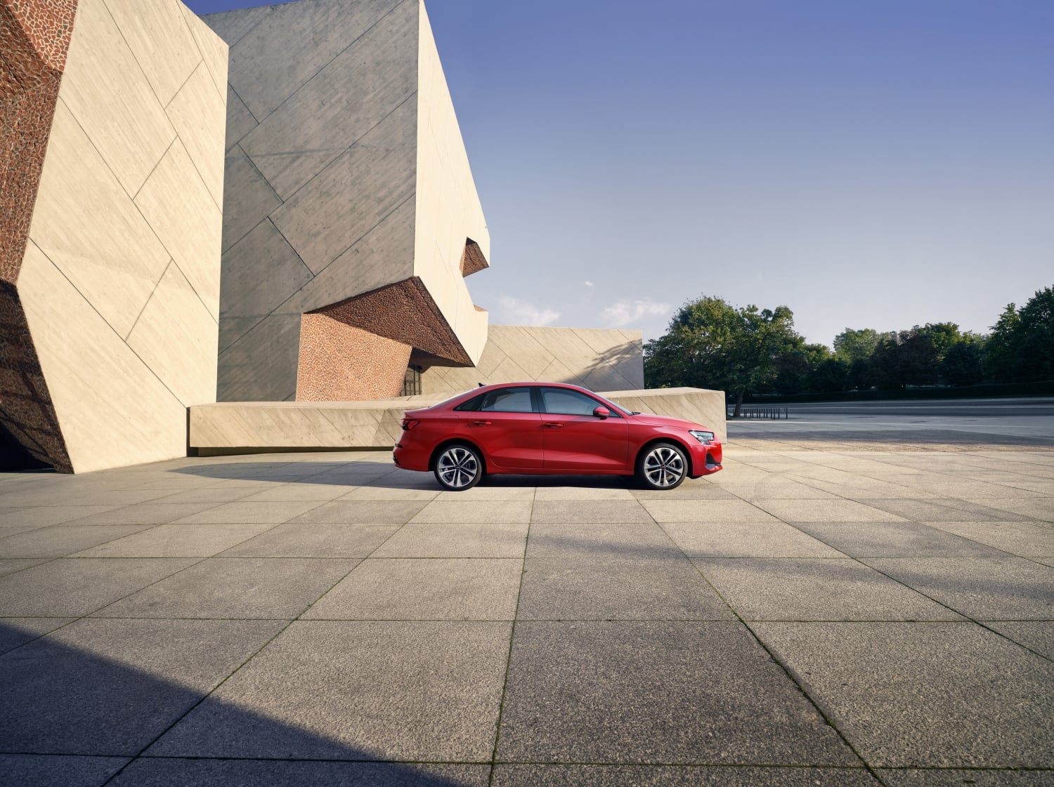 2025 Audi A3 side profile in red parked near modern architecture