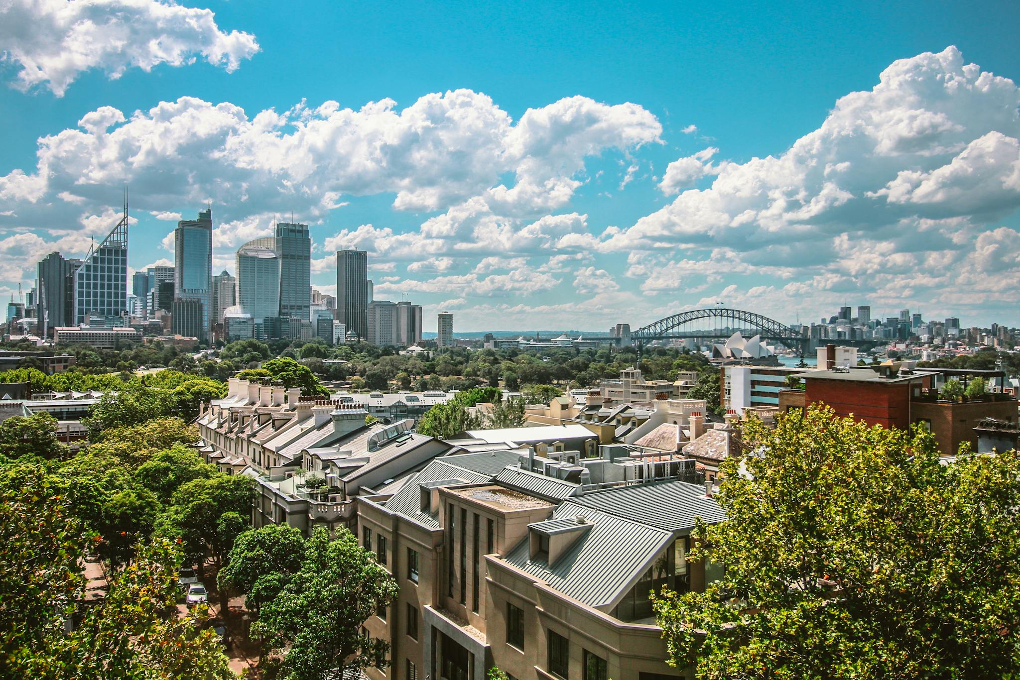 Stunning view of Sydney's skyline featuring the Harbour Bridge and Opera House under a clear blue sky.