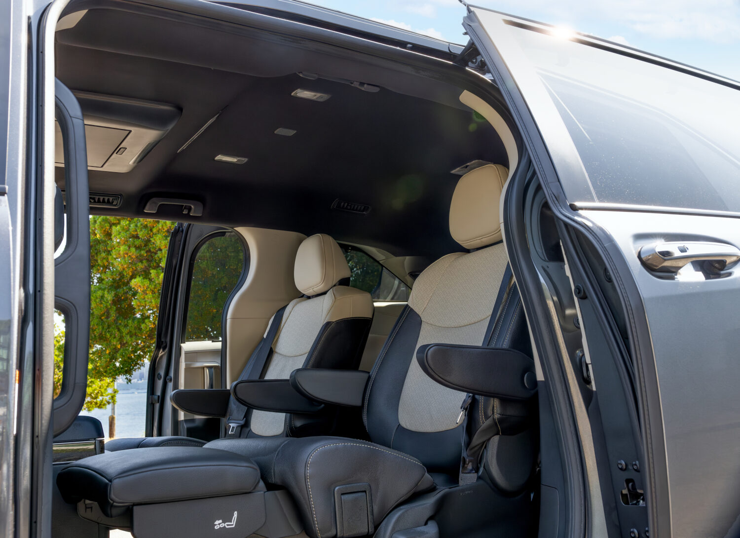 Close-up of the 2025 Toyota Sienna Platinum’s second-row captain’s chairs, featuring beige and black leather upholstery with extended leg rests.