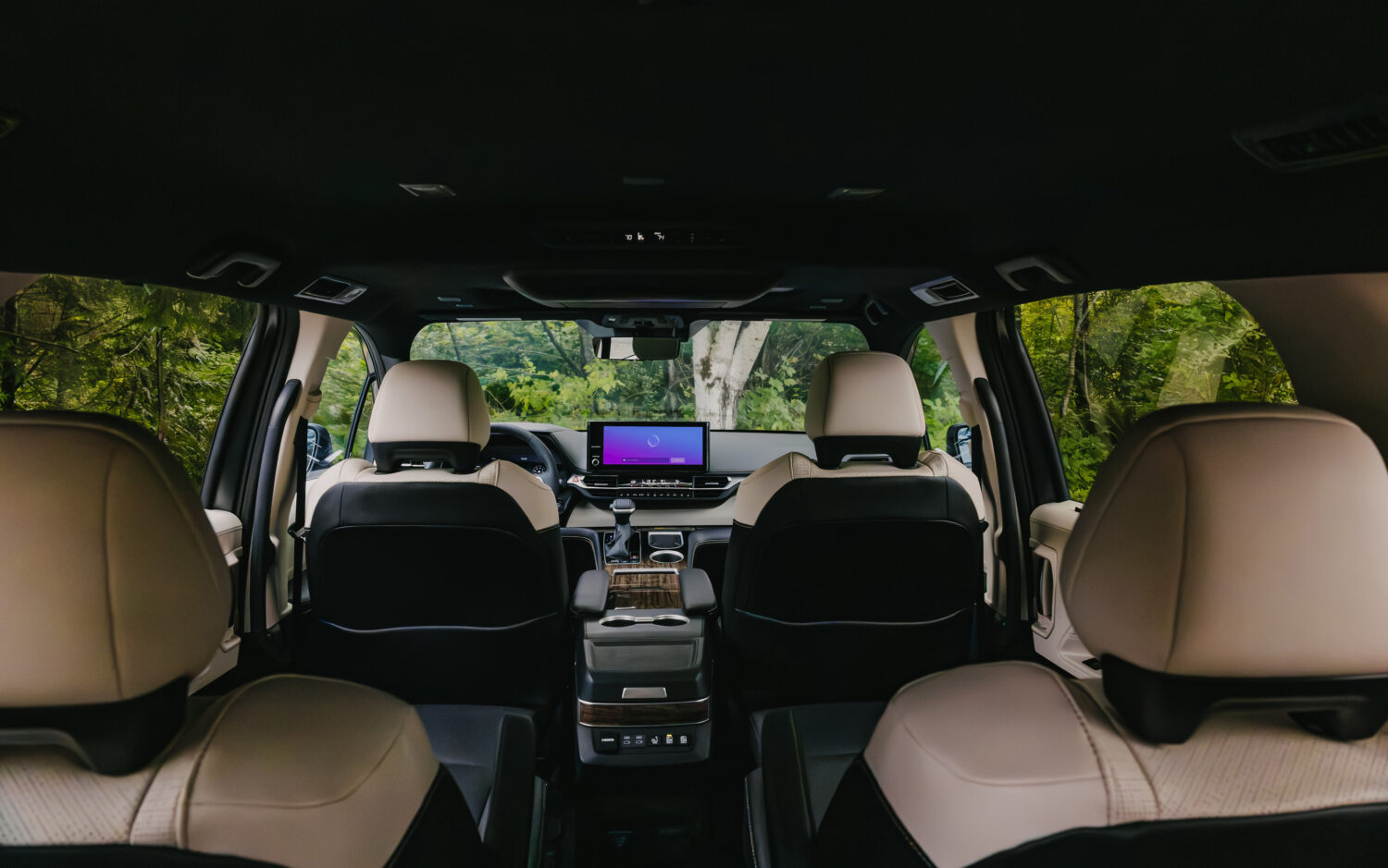 View from the third row of the 2025 Toyota Sienna Platinum showing the digital dashboard, infotainment screen, and premium leather seating.