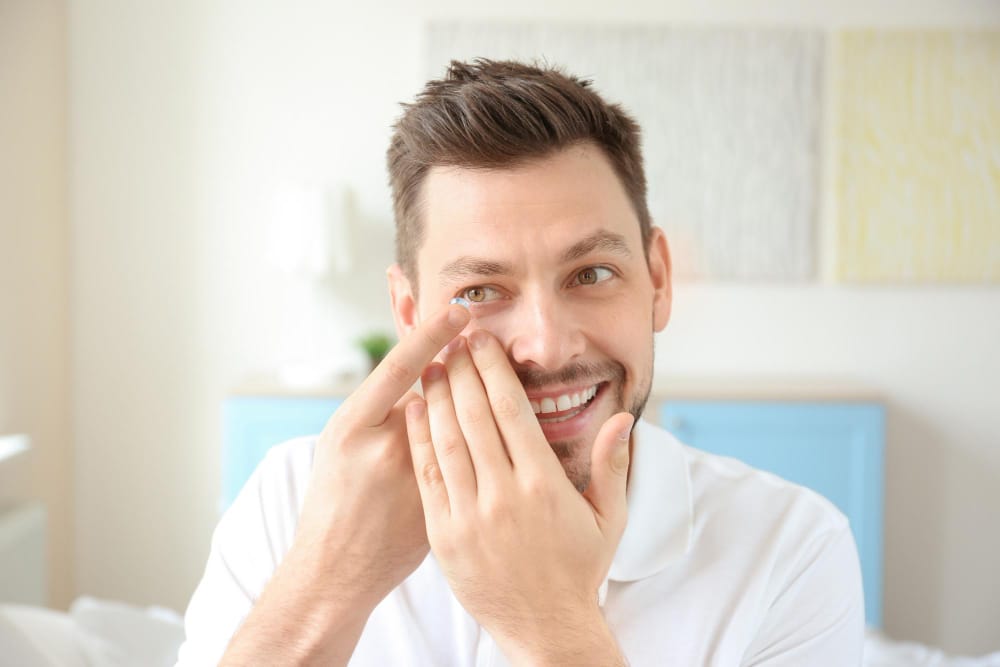 Hand of young man with contact lens