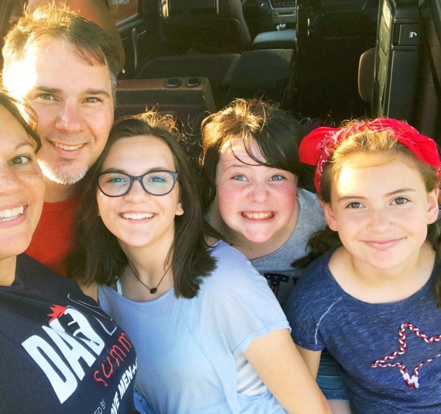 dad smiling with his family including teenagers showing real life parenting and connection