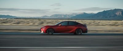 2025 Lexus IS 500 F SPORT Performance in Infrared driving through the desert with mountains in the background