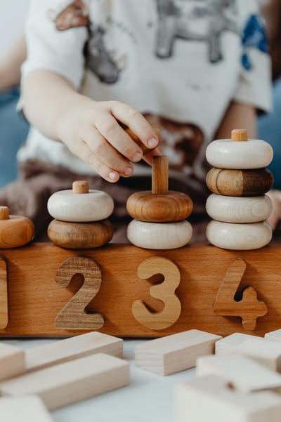 A child interacts with educational wooden number blocks, enhancing cognitive skills.