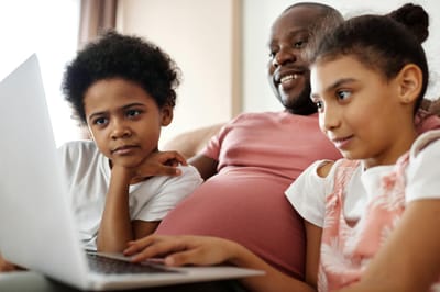 A family enjoying time indoors watching entertainment on a laptop.