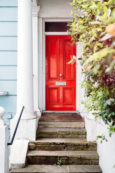 Beautiful red door in a white house facade in notting hill