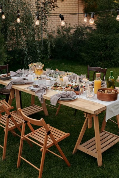 Charming outdoor dining setup with string lights and delicious meals set on a table.