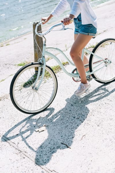 Female riding a bike along the beach