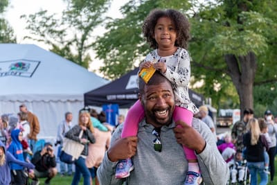 Girl Sitting on Smiling Man's Shoulder
