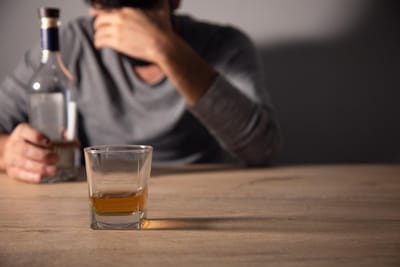 Handsome depressed man drinking whiskey