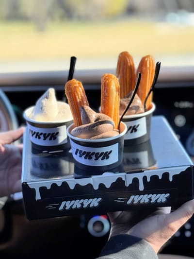 Three IYKYK Mochi Churros served with soft serve ice cream, including chocolate and original churros, photographed after pickup in Dallas.