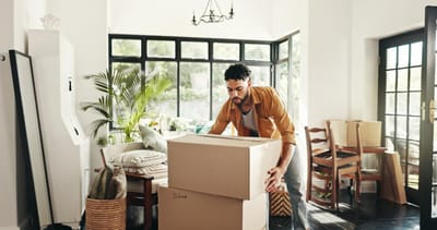 Man packing cardboard boxes in a bright Texas home while preparing for a move.