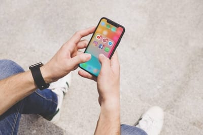 Overhead view of man's hand using social media app on mobile