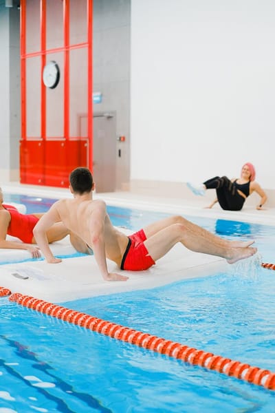 People Exercising on Floating Boards in a Swimming Pool