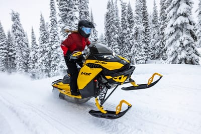 female riding ski doo snowmobile in snow