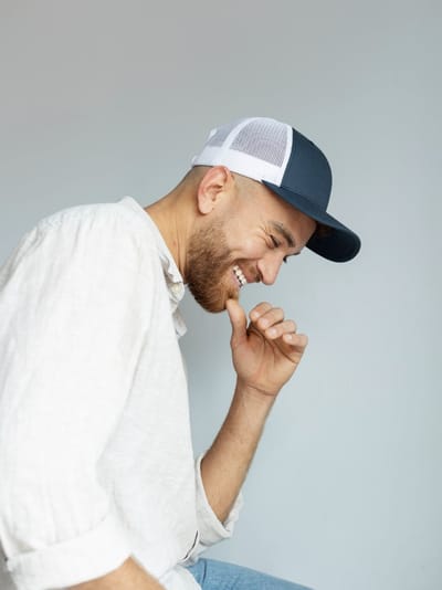 Smiley man posing with trucker hat side view