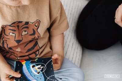 young boy holding space themed card in his lap