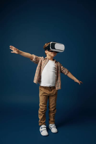 Weightless in the sky. little boy or child in jeans and shirt with virtual reality headset glasses isolated on blue studio ba