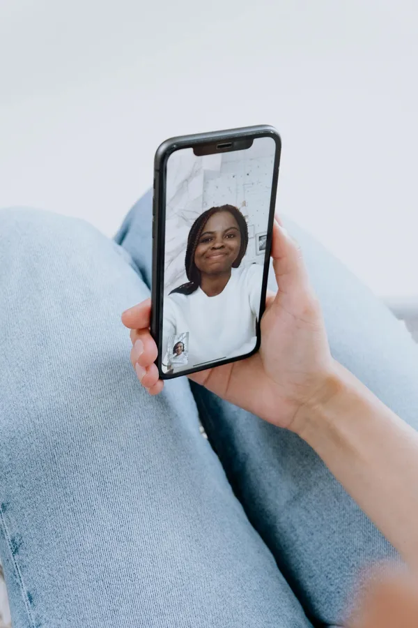 A young woman smiles during a video call on a smartphone, showcasing modern technology and communication.