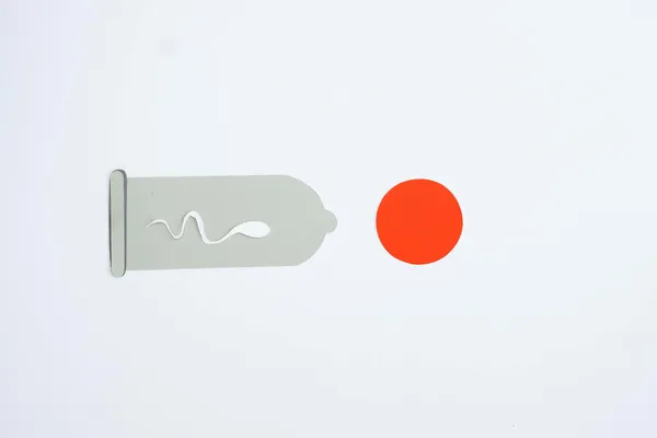 Abstract representation of fertilization with a condom and sperm on a gray background.