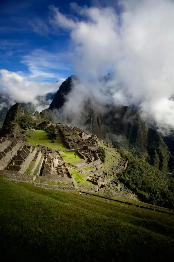 Breathtaking capture of Machu Picchu with dramatic clouds and mountains in Peru.