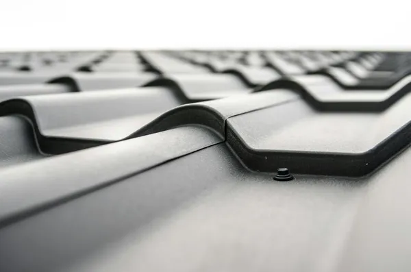 Close-up view of a metal roof's wavy design showcasing rivets and structural detail.