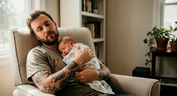 First-time father holding his newborn at home during a quiet bonding moment