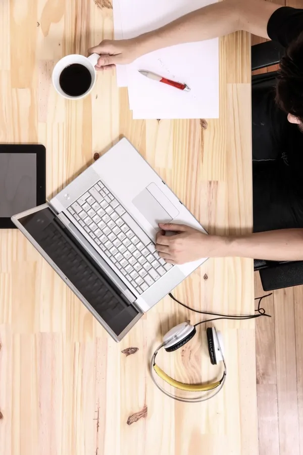 young man working with a laptop and a cup of coffee