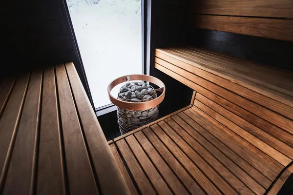 Elegant Nordic sauna interior featuring wooden benches and modern sauna heater.