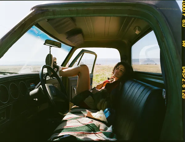 Zendaya reclining inside a pickup truck, representing risky behavior and mature situations depicted in the show Euphoria.