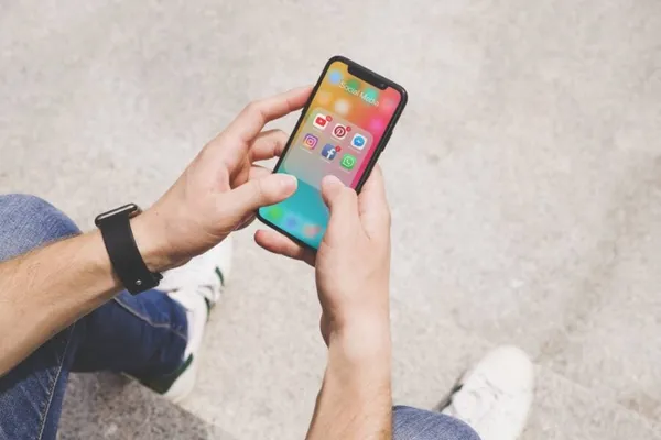 Overhead view of man's hand using social media app on mobile