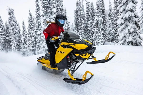 female riding ski doo snowmobile in snow