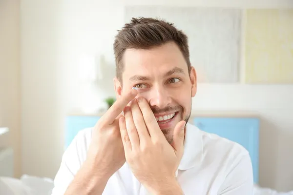 Hand of young man with contact lens