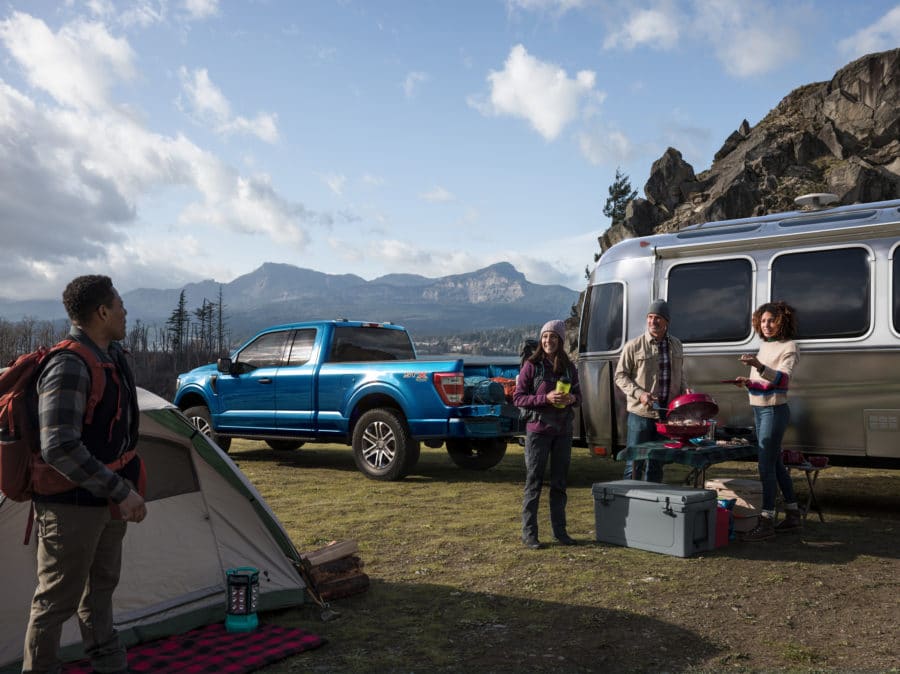 Family and friends camping, with a F-150 and airstream trailer. - Built Ford Tough