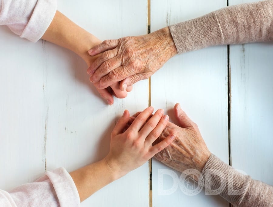 Daughter holding hands elderly woman's