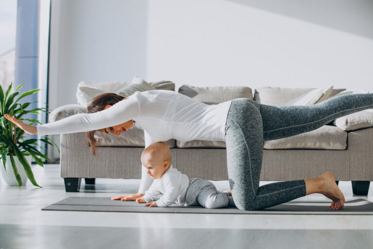 young mom doing yoga while her infant is under her.