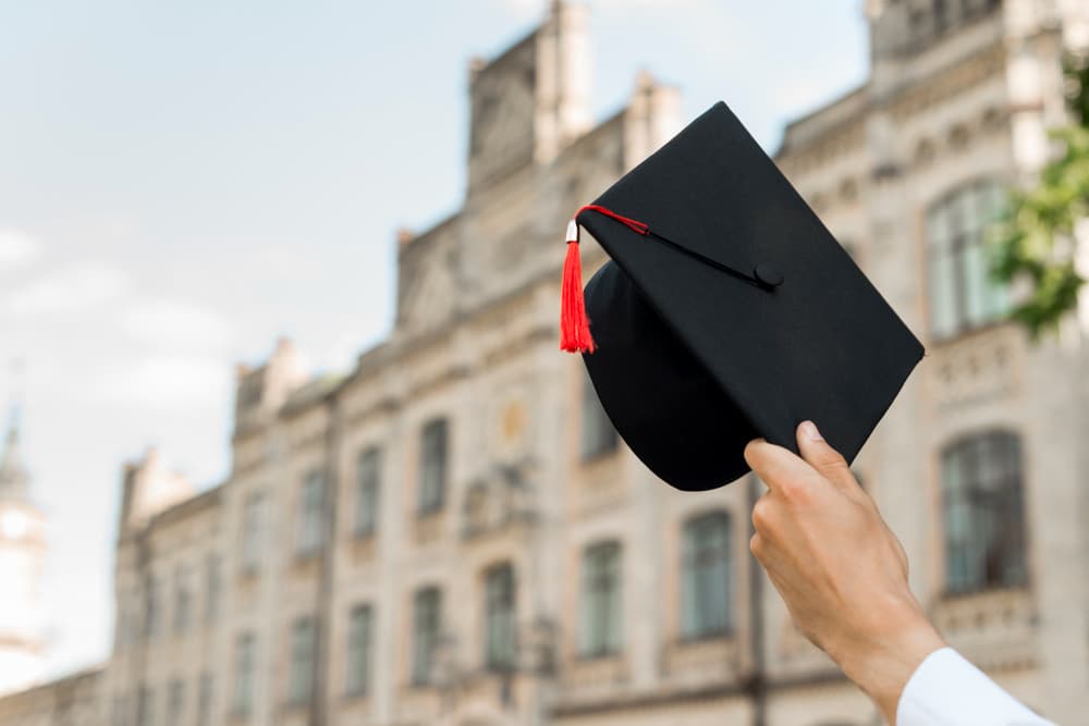 Graduation concept with student holding hat