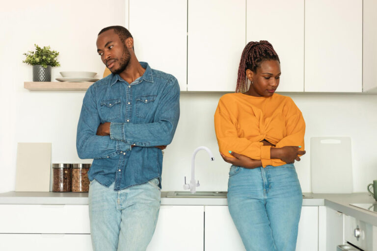 Photo sad african american spouses standing near each other in kitchen offended after quarrel at home