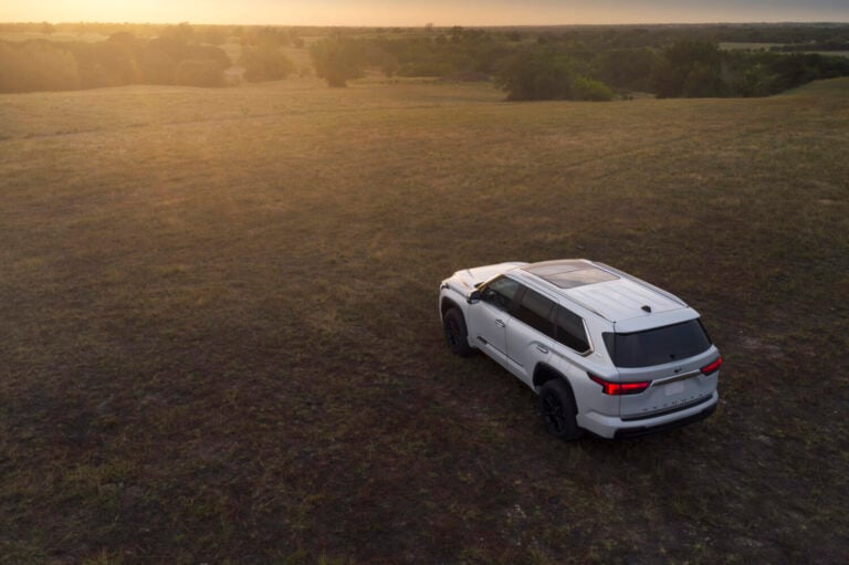 White 2025 Toyota Sequoia 1794 edition parked on an open landscape, showcasing its rugged full-size SUV design and panoramic sunroof.